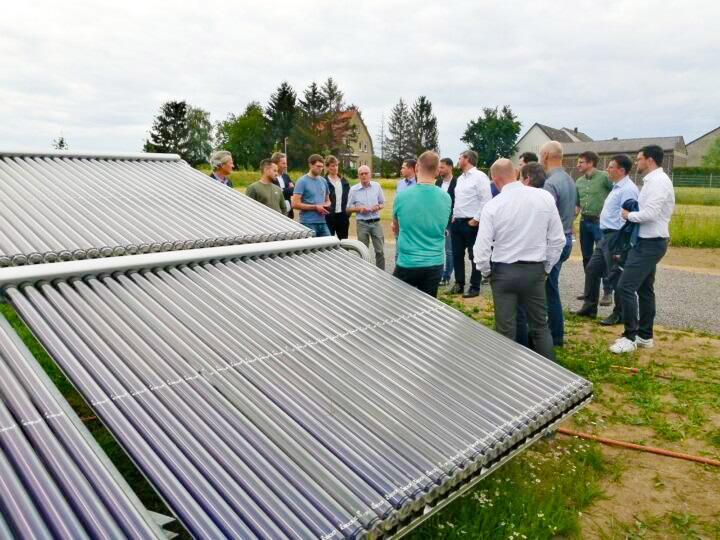 Besichtigung an der iKWK-SOlarthermie-Anlage in Lemgo: Gruppe steht im Kreis am Solarkollektorfeld