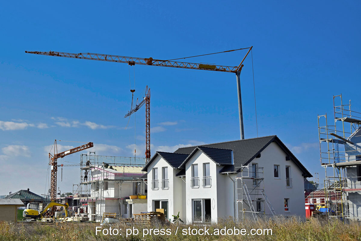 Neubaugebiet mit Doppelhäusern und Baukränen