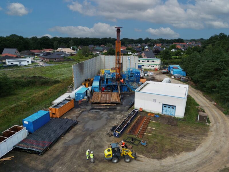 Luftbild einer Baustelle mit Geothermiebohrer und Containern.