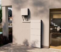 Ein Wechselrichter- und Speichersystem das an der Außenwand eines Hauses installiert ist.