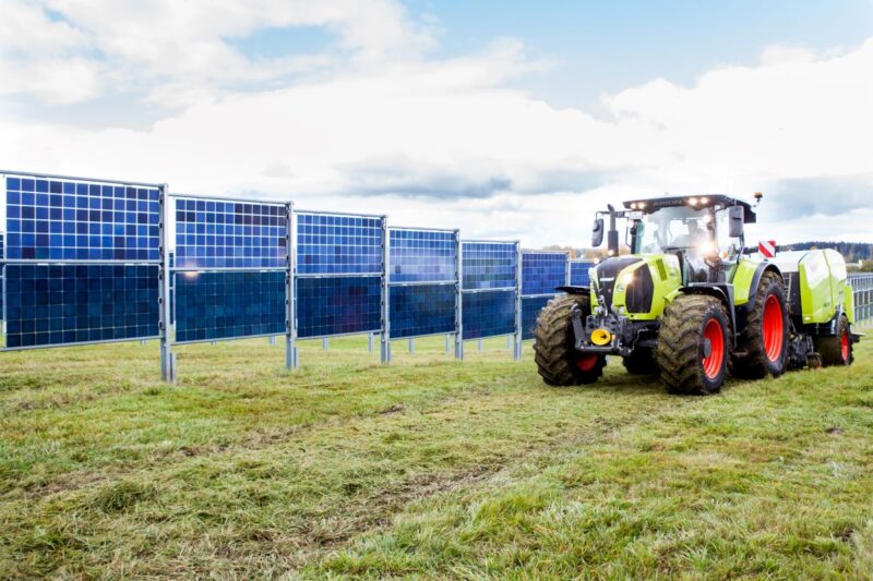 Vertikale, bifaziale Solarmodule auf einem Acker mit Traktorel