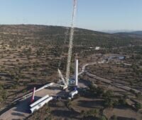 Karge Landschaft, Windenergie-Anlagen im Hintergrund, vorne eine Anlage im Aufbau - Nordex-Auftrag aus Spanien.