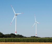 Zwei Windenergieanlagen in einer ländlichen Umgebung.