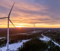 Nordex-Maschinen vom Typ Delta 4000 im schneebedeckten Flachland bei tiefstehender Wintersonne.