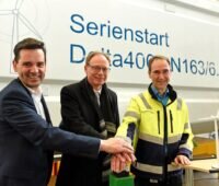 Drei Männer drücken symbolisch auf den Startknopf der Nordex-6 MW-Serienproduktion.
