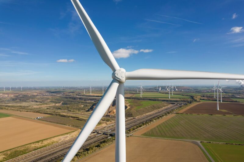 Blick auf die Nabe einer Windkraftanlage an Land. Im Hintergrund weitere Windkraftanlagen.