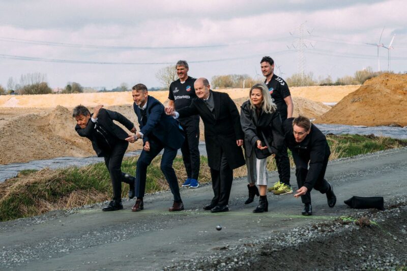 Fünf Personen beim so genannten Bosseln, darunter Kanzler Scholz, Ministerpräsident Günther und Wirtschaftsminister Habeck.