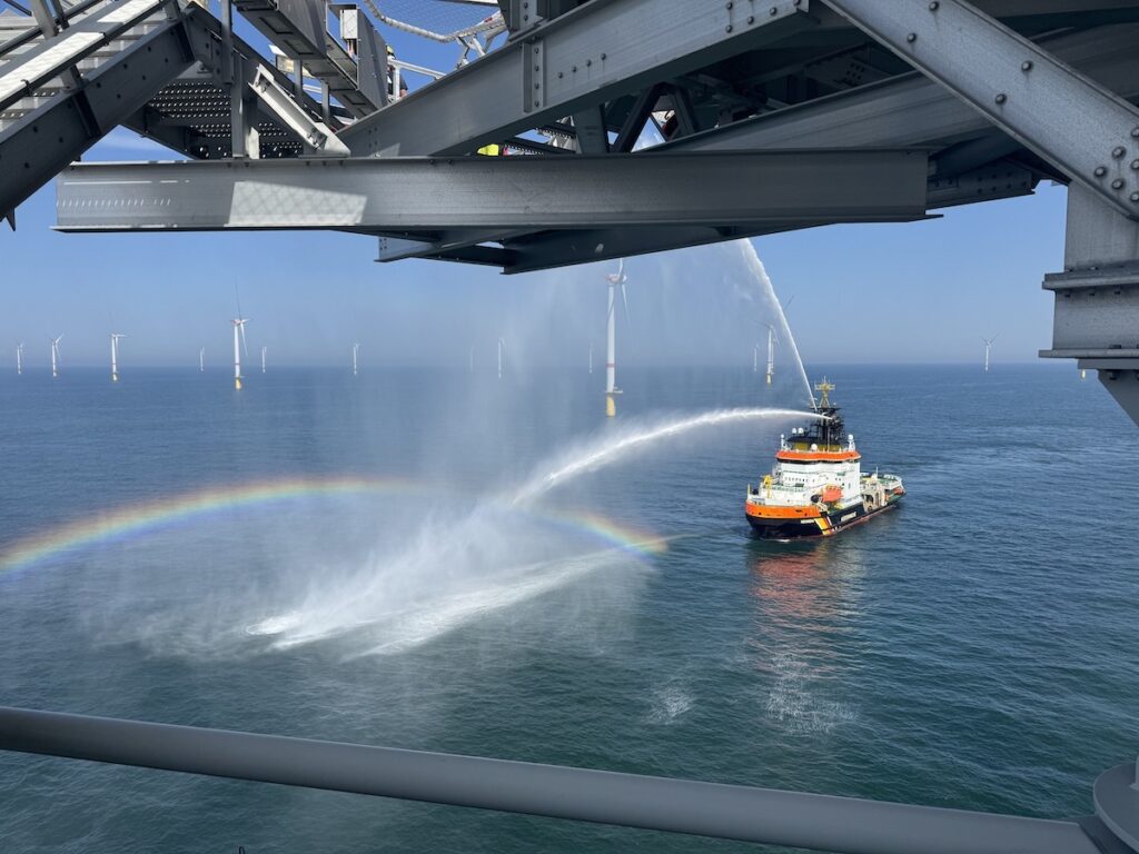 Ein Rettungsschiff macht mit einem Wasserstrahl einen Regegnbogen.