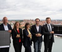 2 Frauen und drei Männer auf einem Hochhausdach mit Solarmodul