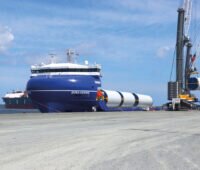 Verladung von Turmsegmenten für Offshore-Windenergie-Anlagen auf ein Schiff.
