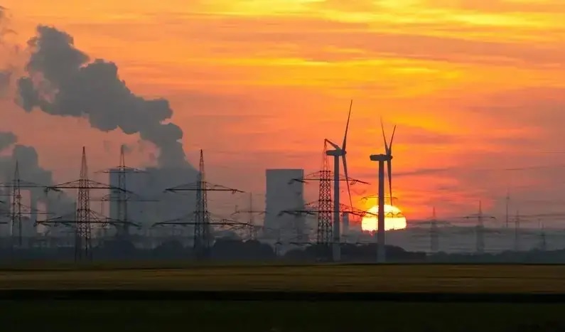 Zu sehen ist ein Kohlekraftwerk vor Windenergieanlagen. Eine Studie des Ökoinstituts will die wissenschaftliche Basis für die Beschleunigung des Kohleausstiegs legen.