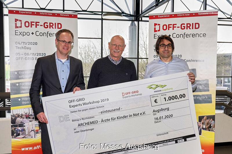 Drei Männer mit symbolischem Scheck über 1000 Euro
