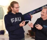 Organische Photovoltaik: Zwei Männer mit kleinem PV-Modul.