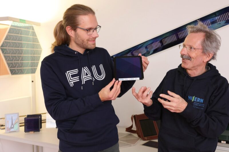 Organische Photovoltaik: Zwei Männer mit kleinem PV-Modul.