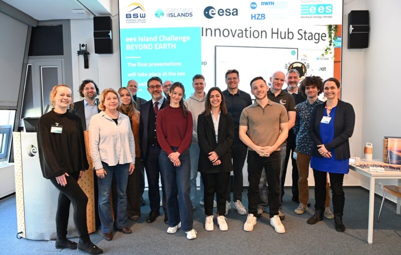 Menschen aufgereiht vor Leinwand, bei der EES Island Challenge entwickeln zwei Teams Konzepte für die Versorgung von Mond-Missionen autark mit Strom auf Basis von Photovoltaik.