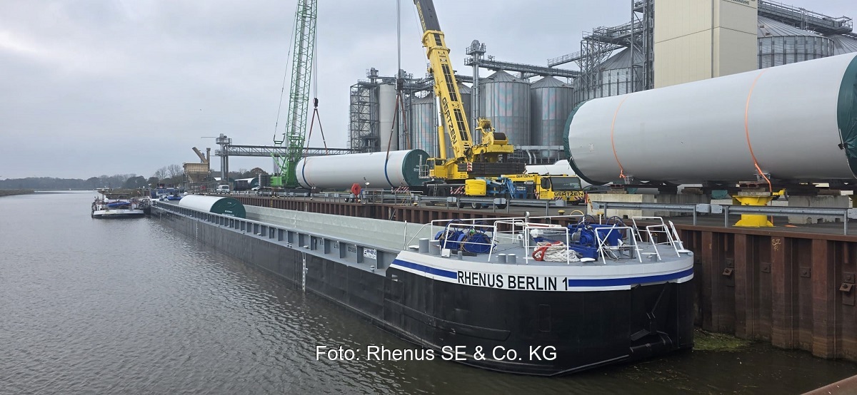 Ein Kran hebt die Stahlturmsektionen der Enercon-Windturbinen vom Schubleichter. Der Transport von Windturbinen-Komponenten auf Wasserwegen bietet Vorteile.