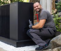Ein Installateur mit Wärmepumpe, Enpal bietet Stadtwerken eine Kooperation bei Wärmepumpen-Installationen an.