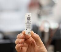 Eine Hand hält eine Rundzelle, das Fraunhofer IPA will umweltfreundliche Batteriespeicher auf LMFP-Basis entwickeln.