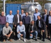 Menschen vor eine Energieanlage beim Kick-off-Treffen des Projektes Biovolatil, das kommunale Energiesysteme stärken will.