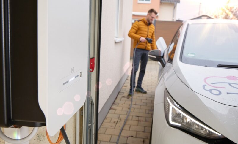 Ein Mann lädt sein Elektroauto, die LEW Verteilnetz GmbH (LVN) testet wie das Elektroauto als Stromquelle dienen kann.