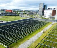 Ein Flachdach eines großen Gebäudes, das mit einer der vertikalen Photovoltaik-Anlagen von Over Easy Solar ausgestattet ist.