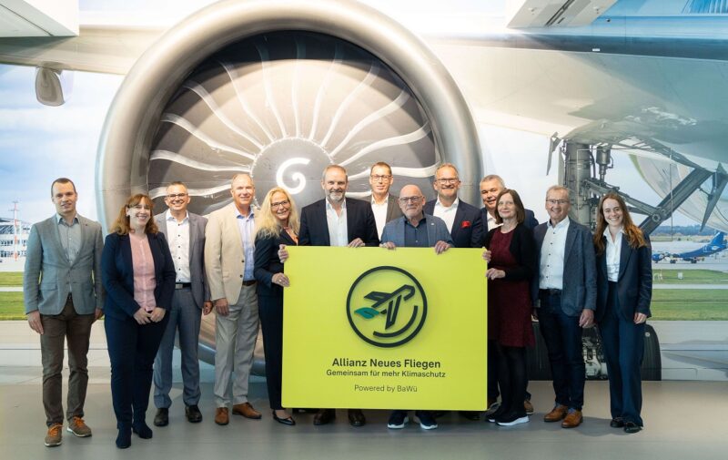 Offizielle und Allianz Baden-Württembergs Verkehrsminister Winfried Hermann stehen in Reihe, um die „Allianz Neues Fliegen“ zur Dekarbonisierung des Luftverkehrs am Flughafen Stuttgart vorzustellen.