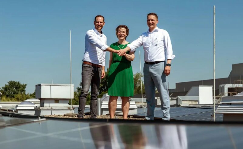 Firmenvertreter:innen von Viventes und den Berliner Stadtwerken auf dem Dach inmitten der Photovoltaik-Anlage.