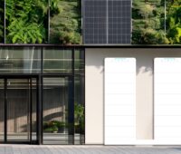 Zwei Photovoltaik-Gewerbespeicher M-ELV BattBank von Atmoce stehen vor einem Gebäude.