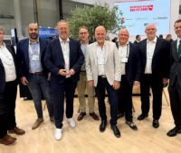Offizielle auf der Messe WindEnergy Hamburg feiern die Ansiedlung des amerikanischen Unternehmens Unimacts im Deutschen Offshore-Industrie Zentrum (DOIZ).