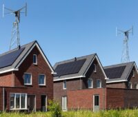 Im Bild Häuser mit Photovoltaik und vertikalen Kleinwindkraft-Anlagen.