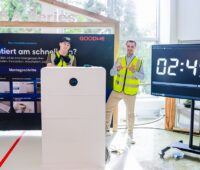 Zwei Installateure mit einem ESA Batteriespeicher von Goodwe.