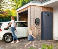 Eine Frau lädt ein Elektroauto, das Heim-Energiemanagementsystem (HEMS) von Lumenhaus bindet den dynamischen Tarif Naturstrom smart ein.