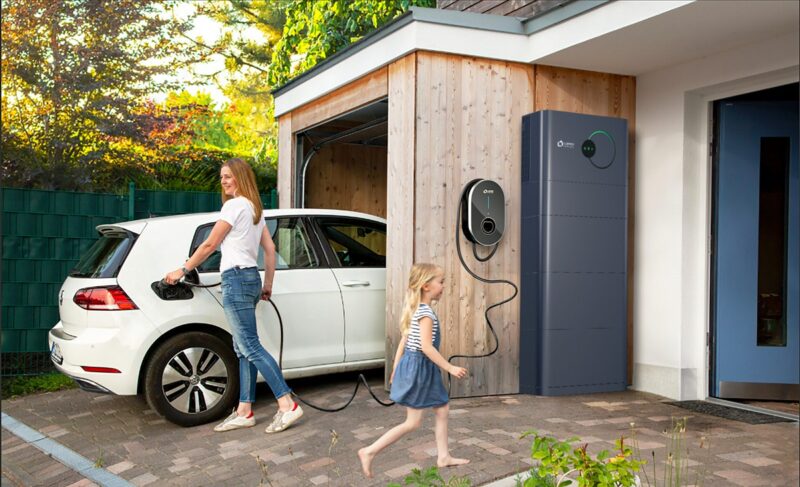 Eine Frau lädt ein Elektroauto, das Heim-Energiemanagementsystem (HEMS) von Lumenhaus bindet den dynamischen Tarif Naturstrom smart ein.