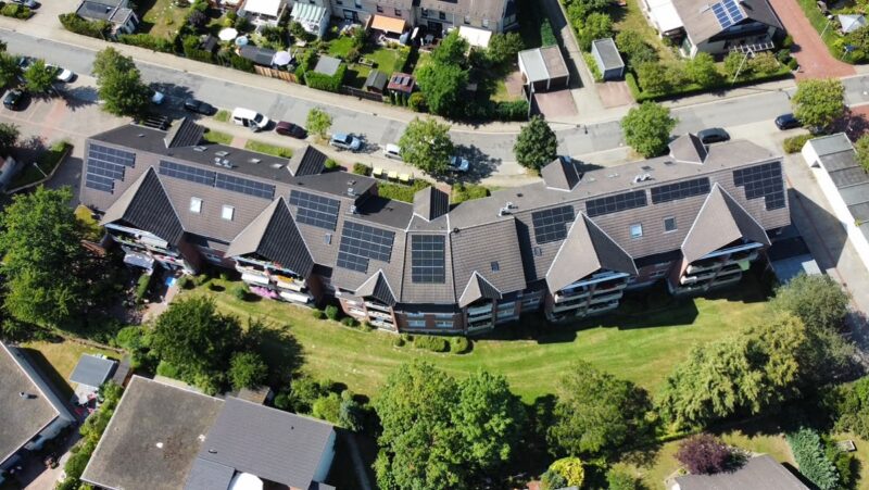 Ein Luftbild der Häuserzeile der Goslarer Wohnstättengesellschaft mit Photovoltaik-Anlagen für die Gemeinschaftliche Gebäudeversorgung.