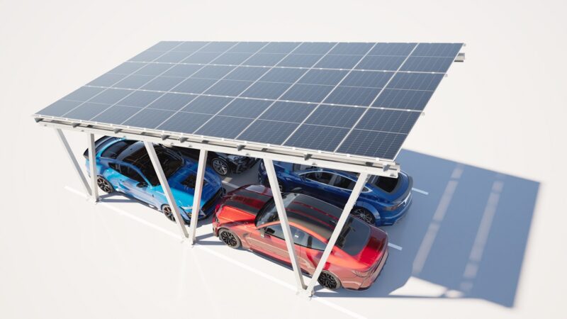 Ein Photovoltaik-Solar-Carport unter dem vier Autos stehen.