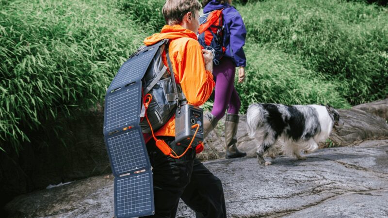 Ein Mann trägt ein faltbares Mini-Solarpanel von Jackery ausgeklappt an seinem Rucksack.