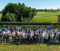 Menschenmenge vor Solarmodulen, Sigenergy und EnBW testen die DC-Kopplung von Photovoltaik-Großspeicher im ZSW-Testfeld in Widderstall bei Merklingen.
