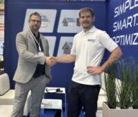 Sebastian Faßbender, Technical Sales Manager DACH bei Sungrow und Pascal Ruisinger, kaufmännischer Geschäftsführer von BRC Solar schütteln Hände; die Unternehmen arbeiten im Bereich Solarmodul-Leistungsoptimierer zusammen.