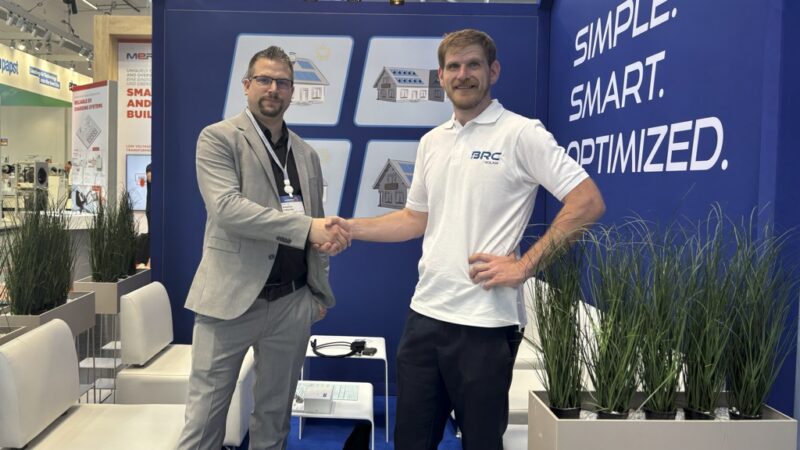 Sebastian Faßbender, Technical Sales Manager DACH bei Sungrow und Pascal Ruisinger, kaufmännischer Geschäftsführer von BRC Solar schütteln Hände; die Unternehmen arbeiten im Bereich Solarmodul-Leistungsoptimierer zusammen.