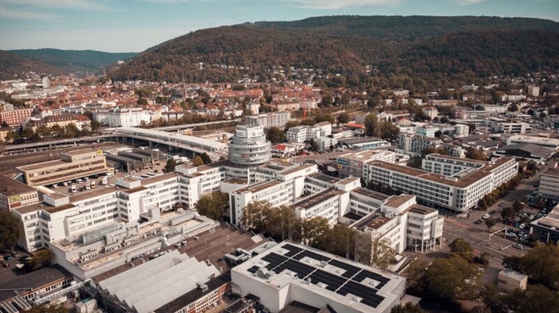 Luftbild von Heidelberg, im Vordergrund die Photovoltaik-Anlage des Heidelberger Bürogebäudes für die gemeinschaftliche Gebäudeversorgung.