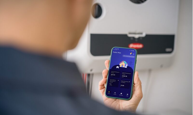 Eine Hand mit Handy, Spotmyenergy bindet Fronius-Wechselrichter in sein Heim-Energiemanagementsystem (HEMS) ein.