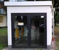 Ein Häuschen auf dem Gelände eines Wohnquartiers mit Komponenten für die gemeinschaftliche Gebäudeversorgung mit einem Quartierspeicher.