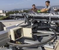 Zwei Forschende der TU Graz neben der faltbaren und nachgeführten, neuartigen Photovoltaik-Anlage.