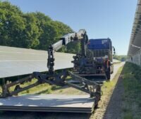 Ein Fahrzeug lädt die Aluminium-Panels für die temporäre Baustraße im Photovoltaik-Solarpark ab.