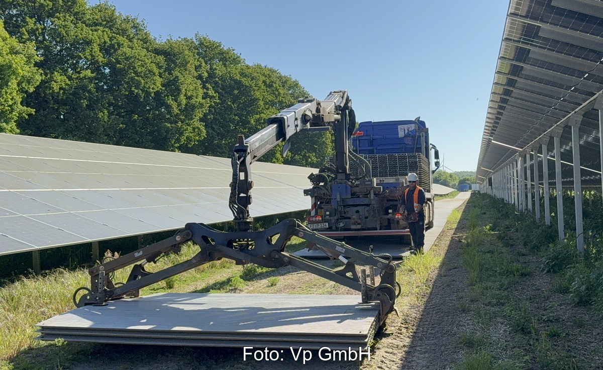 Ein Fahrzeug lädt die Aluminium-Panels für die temporäre Baustraße im Photovoltaik-Solarpark ab.