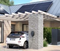 Ein E-Auto vor dem Haus mit Wärmepumpe und Photovoltaik-Anlage von Viessmann.