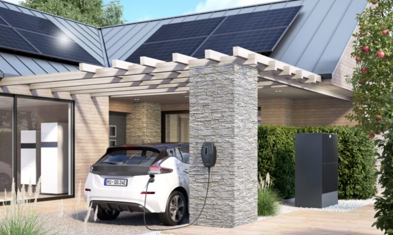 Ein E-Auto vor dem Haus mit Wärmepumpe und Photovoltaik-Anlage von Viessmann.