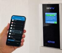 Ein Mann hält ein Handy mit der Setup-App von My-PV, für die Installation von Photovoltaik-Warmwasser-Systemen.