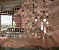 Im Bild Matthew Keyser, leitender Ingenieur für Energiespeicher am NLR hält Kupferscheiben in den Händen, diese sind für eine Untersuchungsmethode für sichere Batteriespeicher in der Raumfahrt relevent.