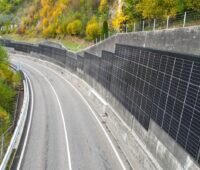 Blick auf die Umgehungsstraße. An der Stützmauer auf der rechten Seite ist eine Photovoltaikanlage installiert.